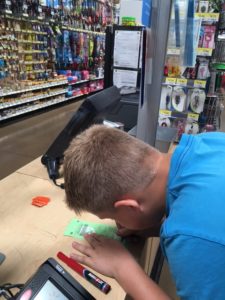 Jonah signing that priceless piece of green plastic paper - His hunting license!